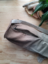 Load image into Gallery viewer,  Yoga mat bag laying on a light wood grain table, shows the natural shade of brown dye on the bag. These yoga mat holders are made and in house at Luna Rose Studio.  
