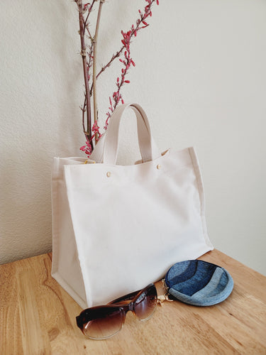 A cleaner cotton Tote bag designed with golden accents to show case the beautiful nature fabric.  This fabric is from CA Cloth Foundry in a natural color with cotton web handles. Medium size travel tote.