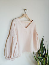Load image into Gallery viewer, Front of pink linen blouse shown hanging inside out showing all seems sewn in french seam finish.
