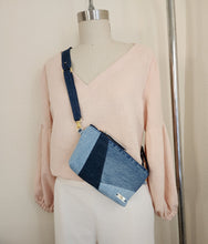 Load image into Gallery viewer, This versatile carryall sling bag has a lightweight webbing strap to wear on the shoulder, crossbody, on belt or wrist.  The bag is sewing in with three shades of denim. Clean seems, modern minimal design with gold hardware accents.  A luxury look to an upcycle 
