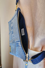 Load image into Gallery viewer, Denim crossbody bag showing gold zipper fully open. The inside lining is dark blue pinstriped. Opening has stop tabs at end. The look of this bag is a perfect calming, joyful blue.
