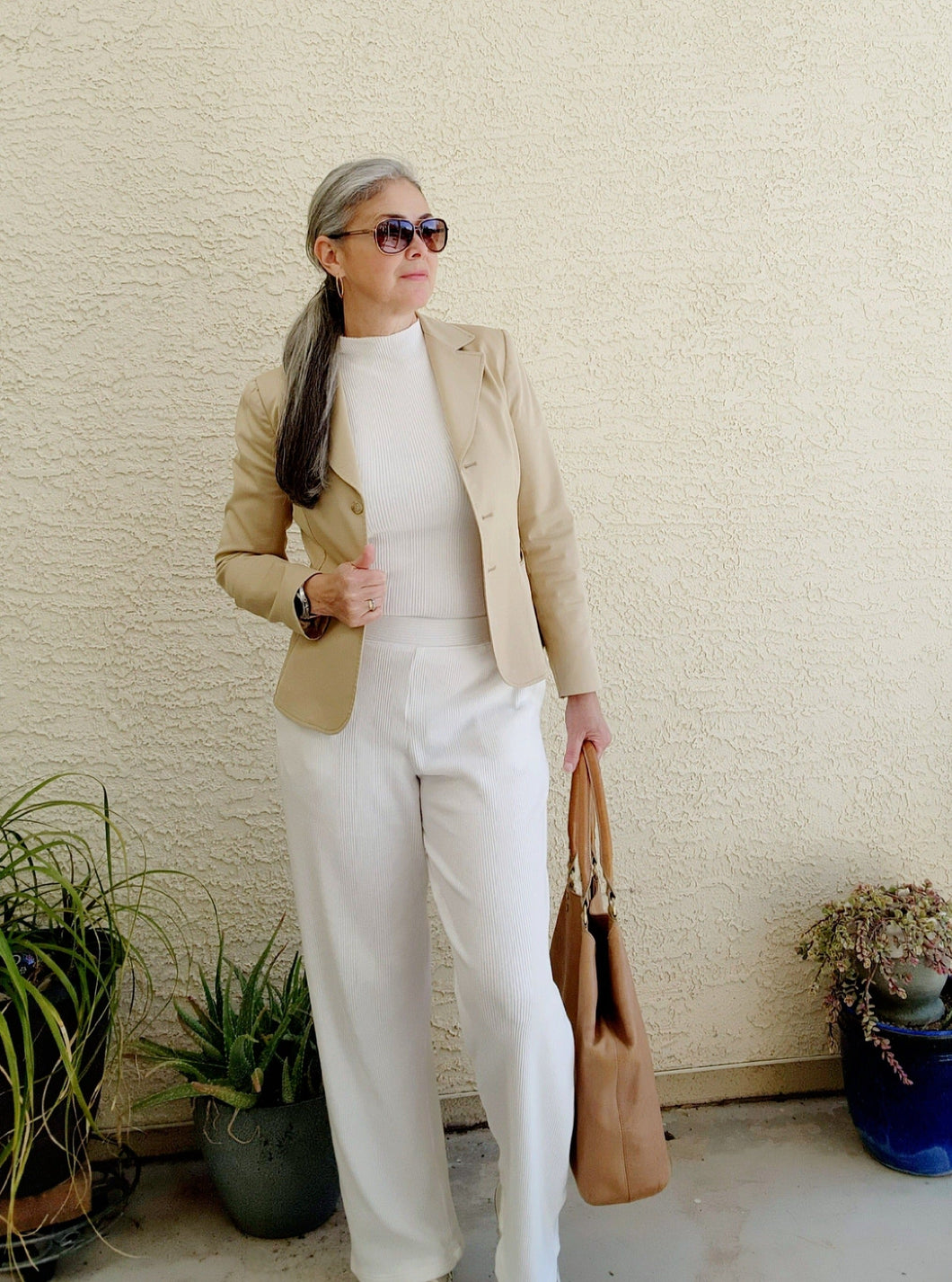 White pant and top styled with a beige jacket, sneakers and leather handbag.  Ethically well-made clothing in Las Vegas NV.